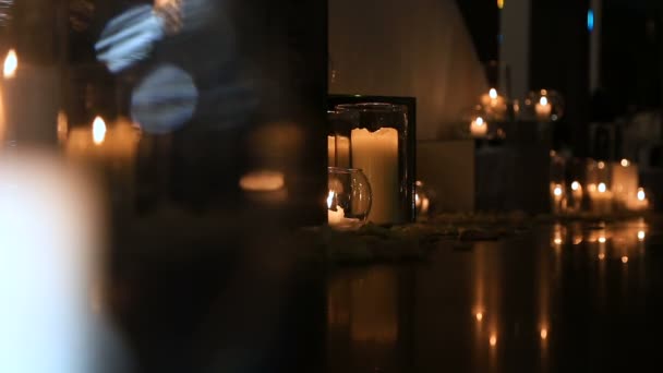 Elegante luz de las velas en el suelo en gafas — Vídeos de Stock