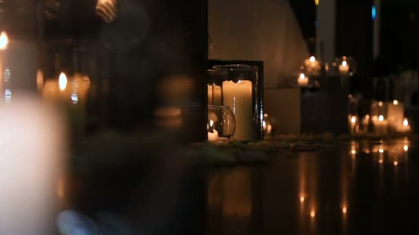 Elegante luz de las velas en el suelo en gafas — Vídeo de stock