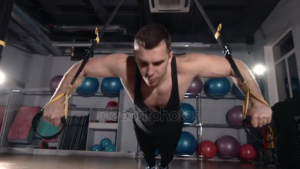 Ejercicio de hombre en un gimnasio mediante el uso de entrenamiento bungee — Vídeos de Stock