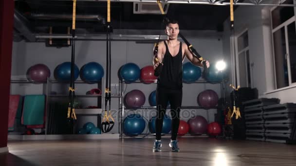 Ejercicio de hombre en un gimnasio mediante el uso de entrenamiento bungee — Vídeos de Stock