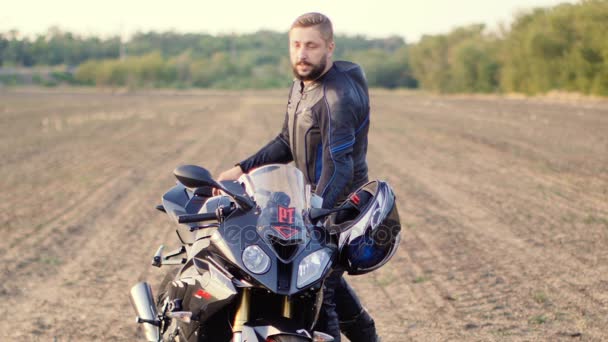 Homem leva um capacete de motocicleta e sorrindo — Vídeo de Stock