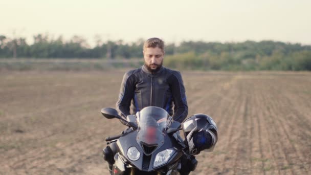 Homem leva um capacete de motocicleta e sorrindo — Vídeo de Stock