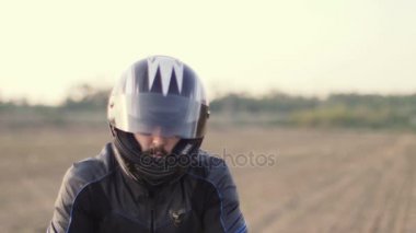 Erkek motorcu motosiklet kask üzerinde koyarak.