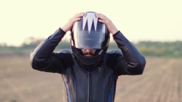 Hombre motociclista que se pone el casco de la motocicleta . — Vídeos de Stock