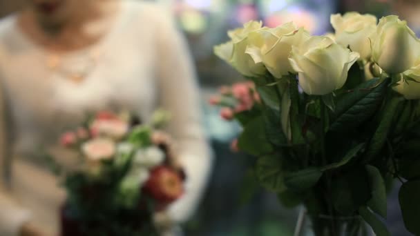 Jovem florista do sexo feminino trabalhando no balcão na loja de flores . — Vídeo de Stock