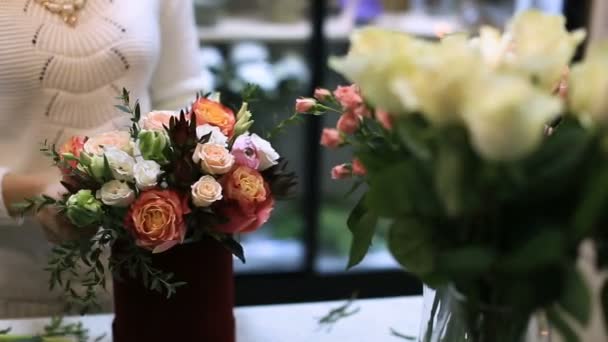 Jovem florista do sexo feminino trabalhando no balcão na loja de flores . — Vídeo de Stock