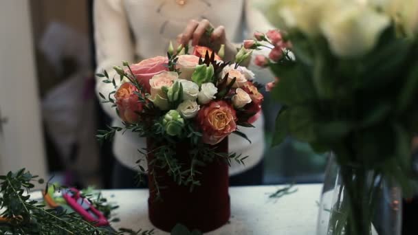 Young female florist working at counter in flower shop. — Stock Video