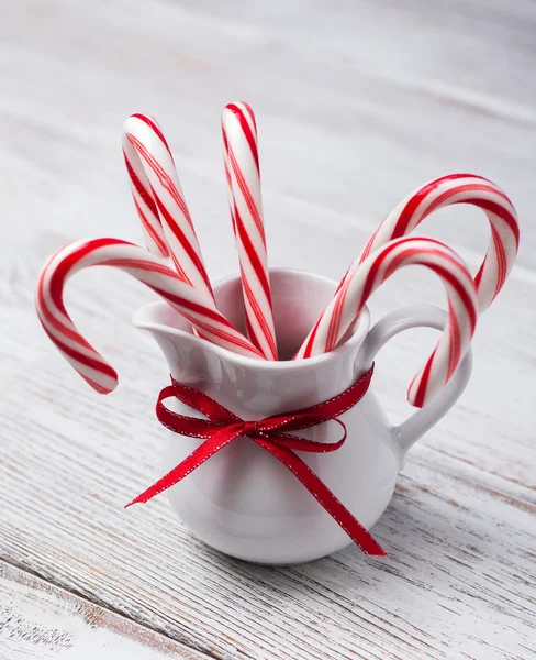 Kruik met kerst candy canes op een houten tafel — Stockfoto