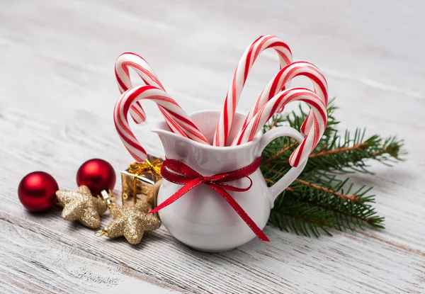 Jarra con bastones de caramelo de Navidad en una mesa de madera — Foto de Stock