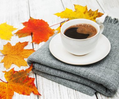 Bir fincan kahve ve sonbahar yaprakları.