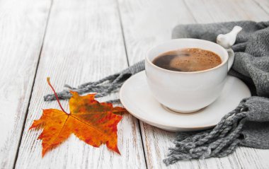 Bir fincan kahve ve sonbahar yaprakları.