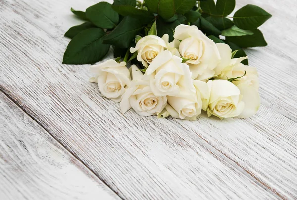 Rosas blancas sobre una mesa de madera — Foto de Stock