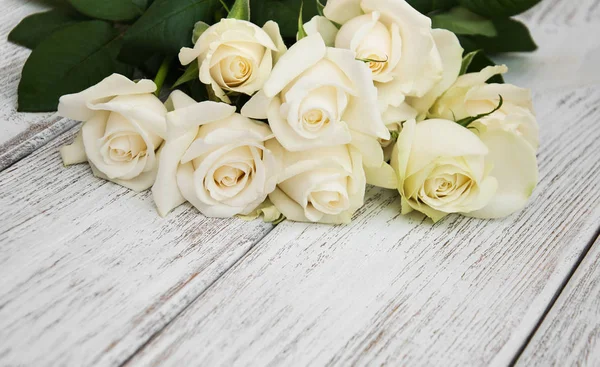 Rosas blancas sobre una mesa de madera — Foto de Stock