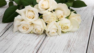 Ahşap bir masa üzerinde beyaz güller