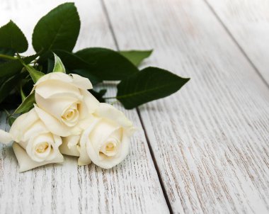 Ahşap bir masa üzerinde beyaz güller