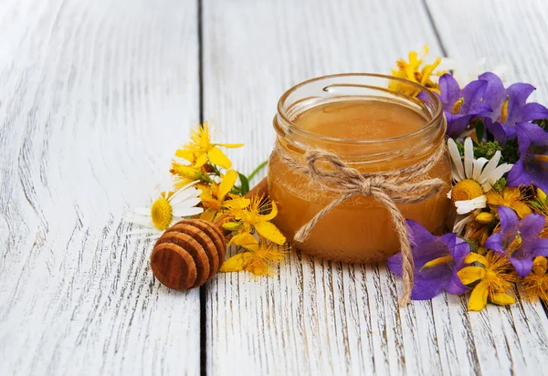 Tarro de miel con flores silvestres — Foto de Stock
