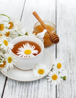 Papatya çiçekli bir fincan bitki çayı.