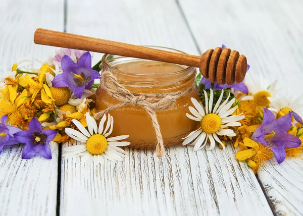 Frasco de mel com flores silvestres — Fotografia de Stock