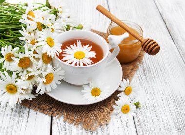 Papatya çiçekli bir fincan bitki çayı.