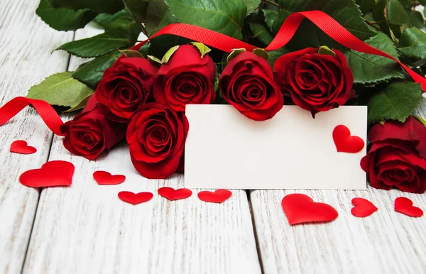 Rosas rojas y tarjeta de felicitación — Foto de Stock