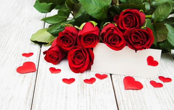 Червоні троянди та вітальна листівка — стокове фото