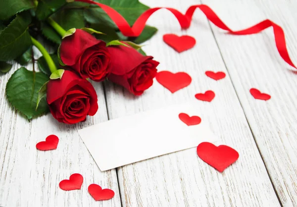 Rosas rojas y tarjeta de felicitación —  Fotos de Stock