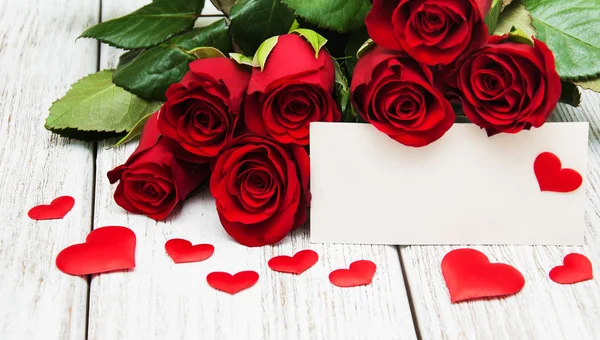 Κόκκινα τριαντάφυλλα και ευχετήρια κάρτα — Φωτογραφία Αρχείου