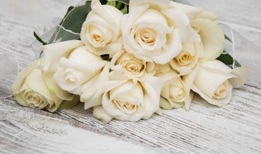 Ahşap bir masa üzerinde beyaz güller