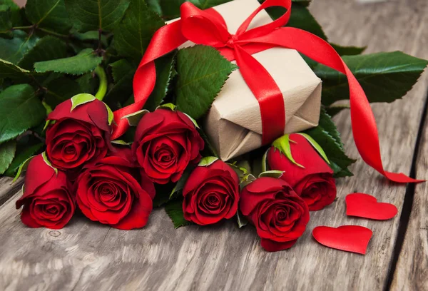 Röda rosor och presentförpackning — Stockfoto
