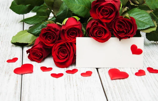 Rosas rojas y tarjeta de felicitación — Foto de Stock