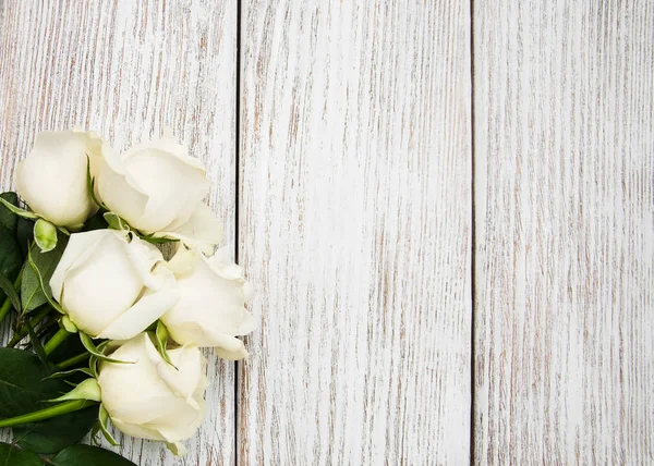 Rosas blancas sobre una mesa de madera — Foto de Stock