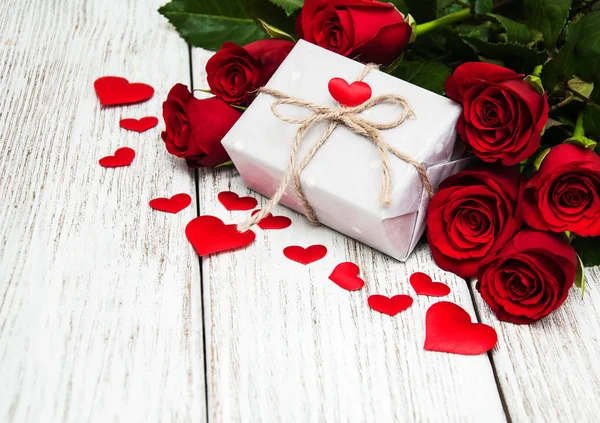 Красные розы и подарочная коробка — стоковое фото