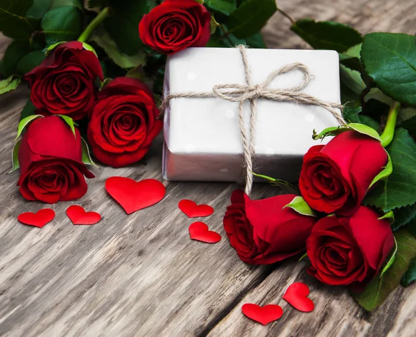 Röda rosor och presentförpackning — Stockfoto