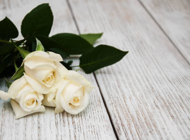 Ahşap bir masa üzerinde beyaz güller