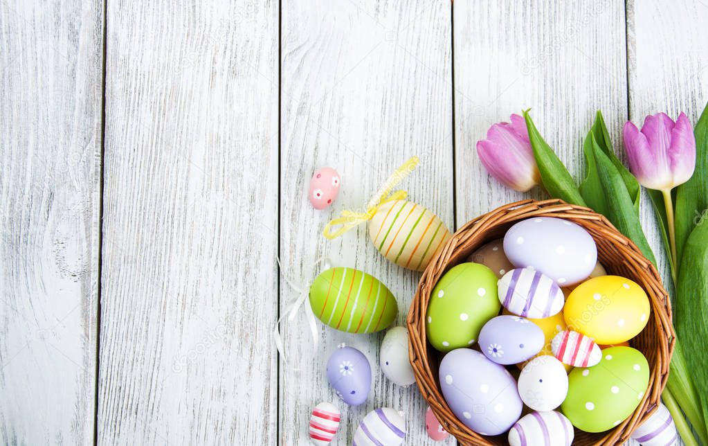 basket with easter eggs and tulips