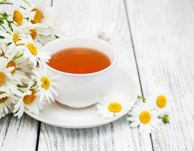 Papatya çiçekli bir fincan bitki çayı.