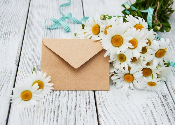 Boeket van madeliefjes met envelop — Stockfoto