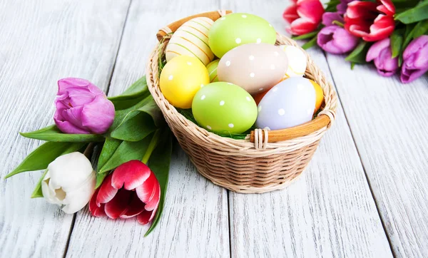 Basket with easter eggs and tulips — Stock Photo, Image