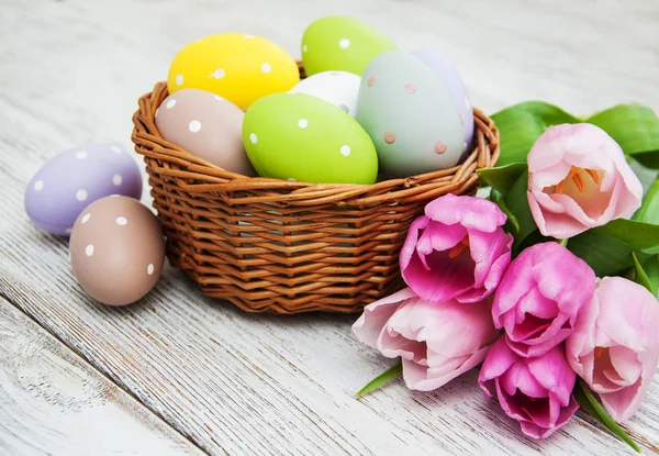 Basket with easter eggs and tulips — Stock Photo, Image