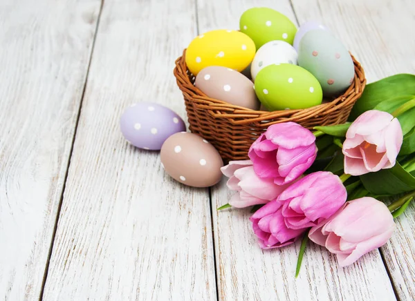 Basket with easter eggs and tulips — Stock Photo, Image