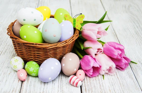 Basket with easter eggs and tulips — Stock Photo, Image