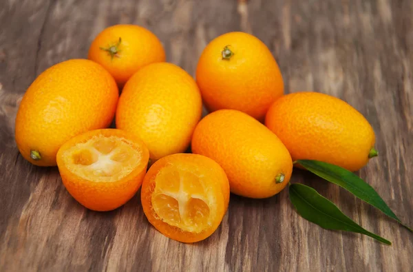 Kumquats em uma mesa de madeira — Fotografia de Stock