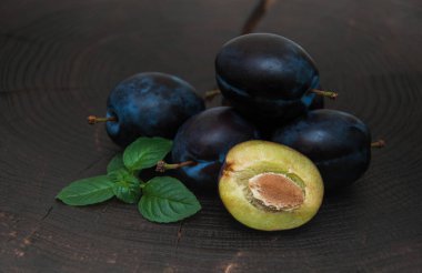 Fresh plums with green leaves