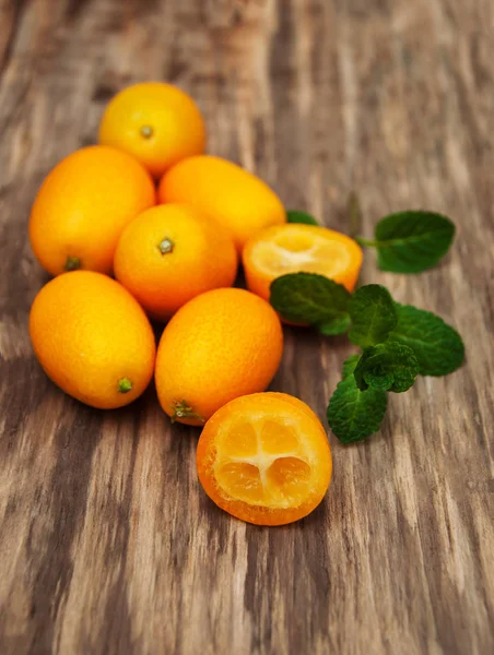 Kumquats em uma mesa de madeira — Fotografia de Stock