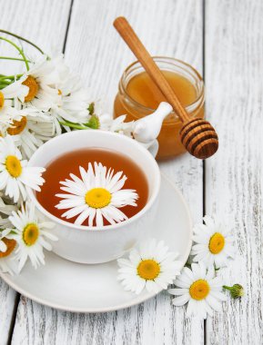 Papatya çiçekli bir fincan bitki çayı.