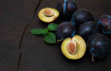Fresh plums with green leaves