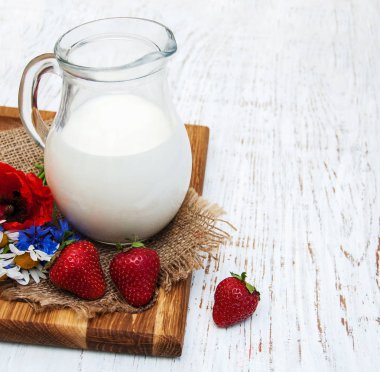 Süt ve kır çiçekleri ile sürahi