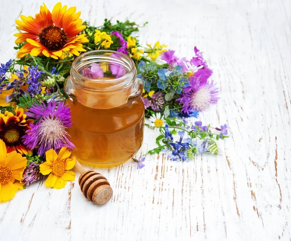 Vidro com mel e flores silvestres — Fotografia de Stock