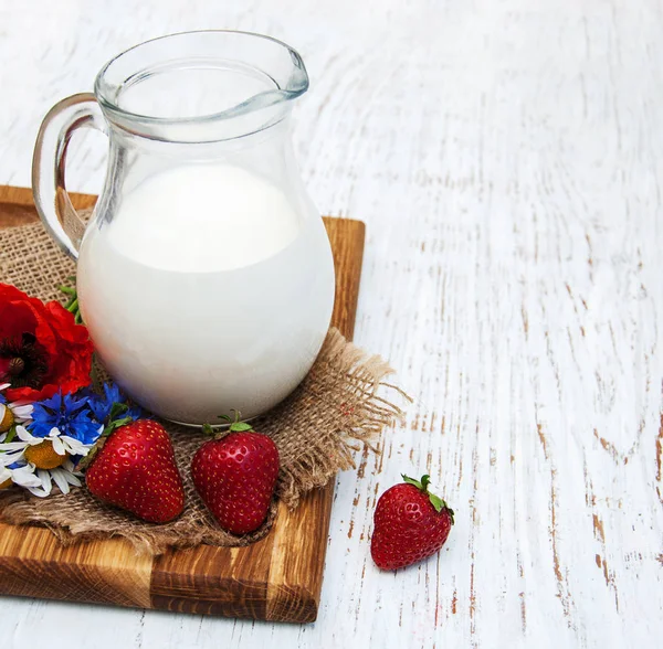 Süt ve kır çiçekleri ile sürahi