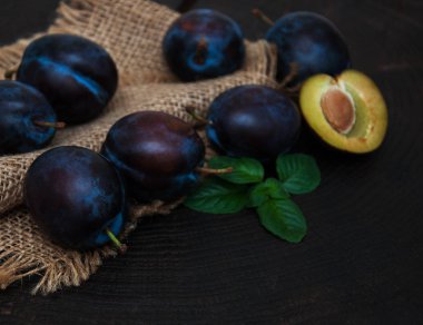 Fresh plums with green leaves